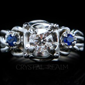 Four-piece engagement puzzle ring with a round center diamond and two round side sapphires