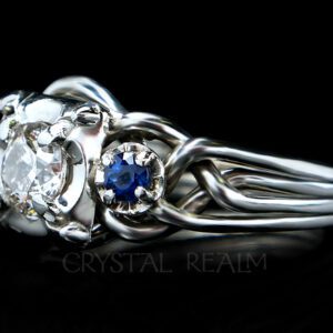Four band puzzle ring with round center diamond and two blue sapphire accents