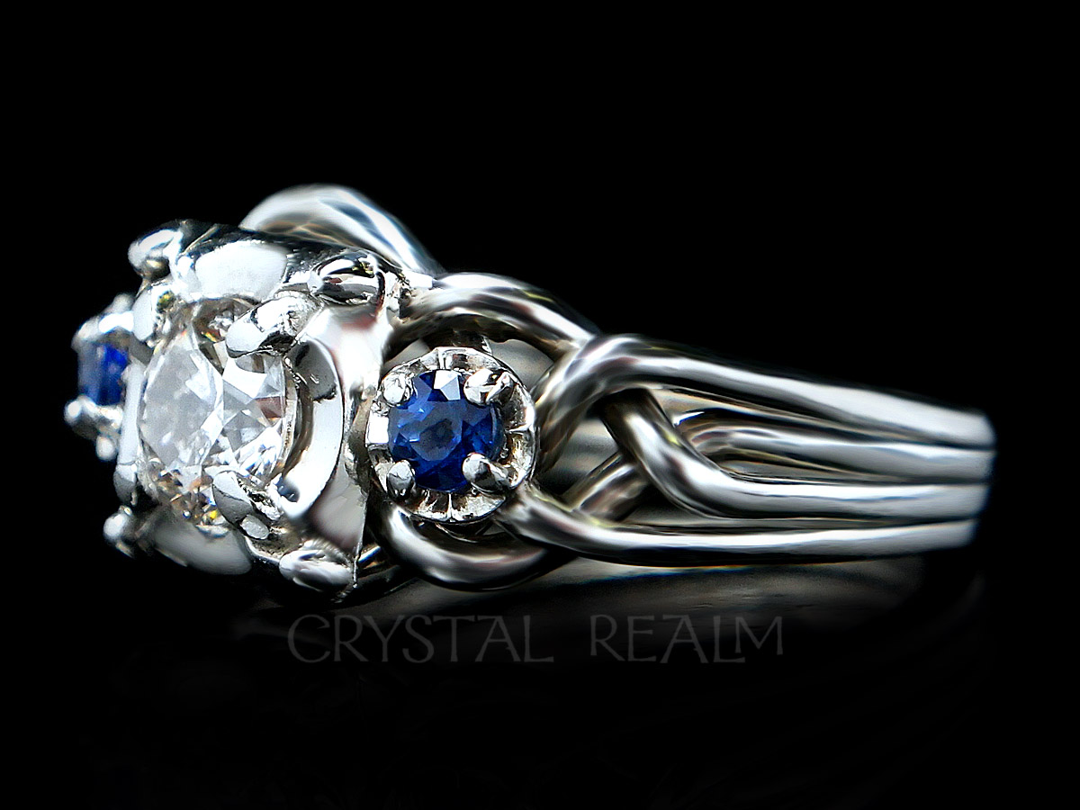 Four band puzzle ring with round center diamond and two blue sapphire accents